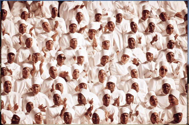 Black Muslim Women Dressed In White Applaud Elijah Muhammad During The Delivery Of His Annual Savior's Day Message In Chicago, 03/1974